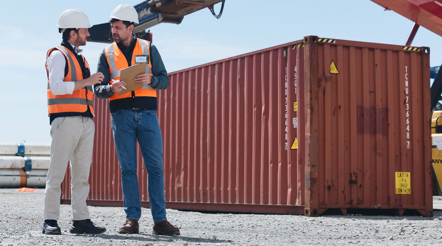 Expert logistique inspectant un conteneur maritime et vérifiant la plaque de certification CSC lors d'un contrôle qualité